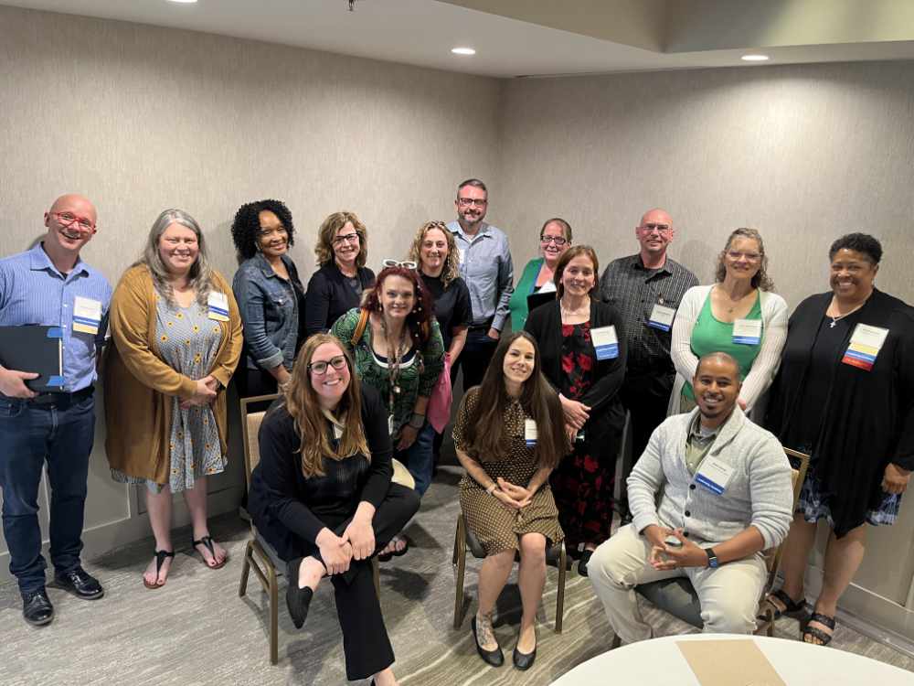 Members of the Leadership Academy class of 2024 stand gathered together after graduation ceremony